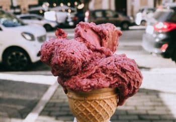 Close-up of a pink gelato cone held outdoors in Rome, Italy. Perfect treat on a sunny day.