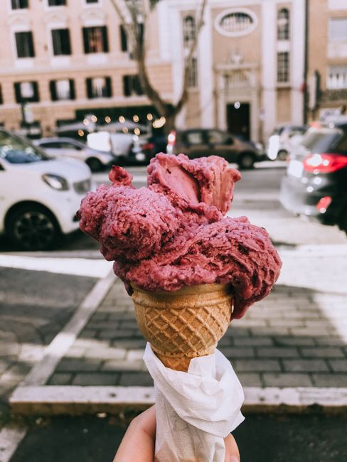 Close-up of a pink gelato cone held outdoors in Rome, Italy. Perfect treat on a sunny day.