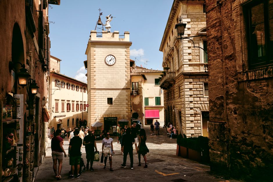 Explore the historic and charming streets of Montepulciano, Tuscany, with its iconic clock tower and old town vibe.
