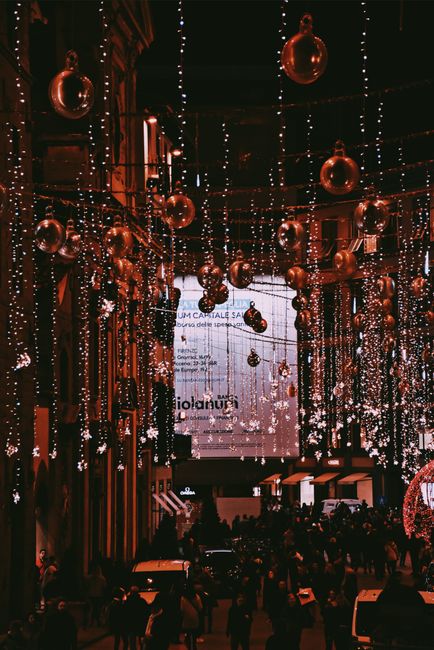 Captivating Christmas lights and decorations illuminate a busy street in Florence at night.