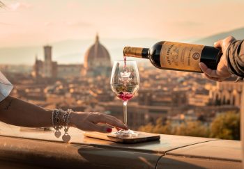 Elegant wine pouring scene with Florence's iconic skyline and cathedral in the backdrop.