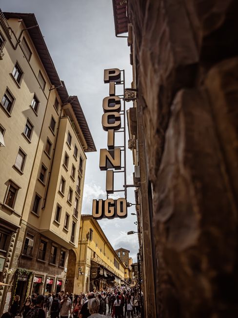 Crowded street scene in Florence, Italy with historic buildings and vibrant urban life.