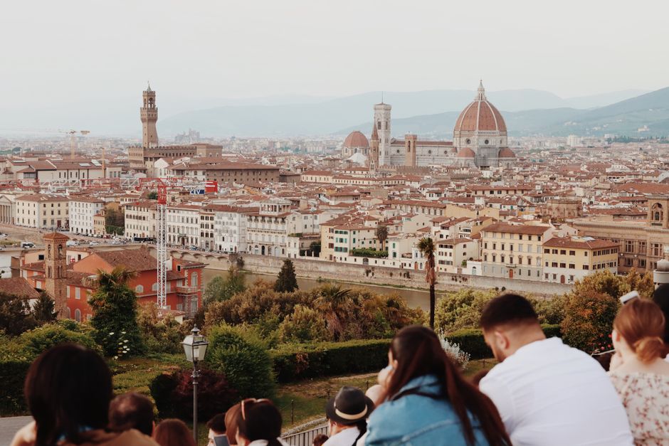 Panoramic view of Florence featuring the iconic Santa Maria del Fiore and Arno River with people enjoying the scene.