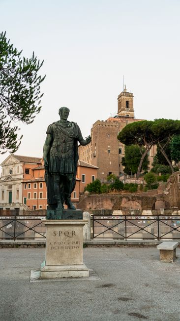 A historic statue of a Roman figure in a scenic Roman square, showcasing ancient architecture.