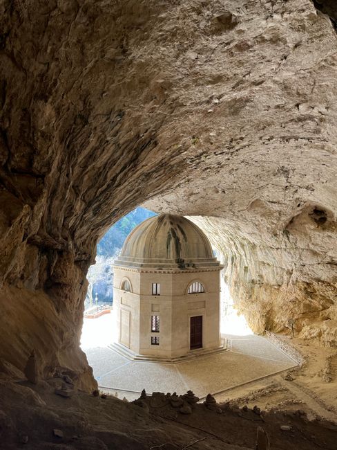 Discover the serene beauty of an ancient temple nestled within a grand limestone cave.
