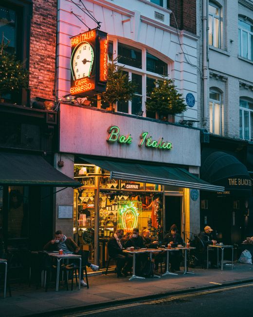 Charming nighttime street scene outside Bar Italia in London, capturing a cozy urban atmosphere.