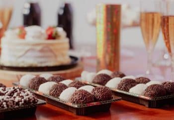 A sophisticated party setup featuring a cake, truffles, and champagne flutes, perfect for a cheerful celebration.