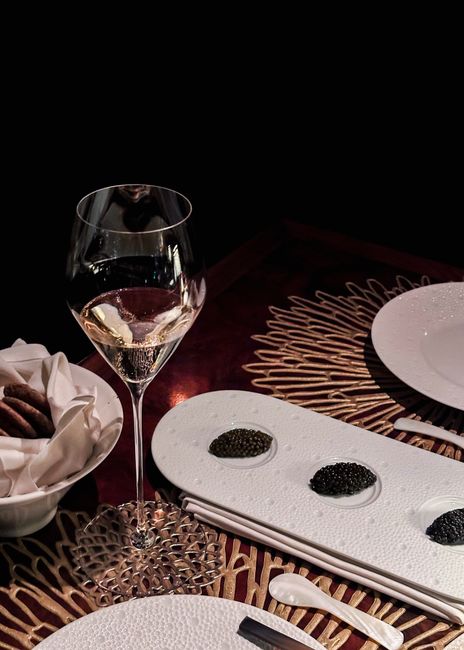 Luxurious dining setup featuring caviar and white wine, perfect for gourmet experiences.