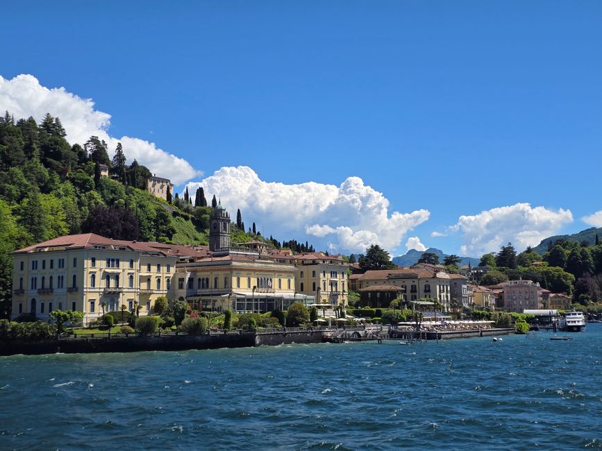 Charming Bellagio waterfront with historic buildings on Lake Como under a vibrant blue sky.