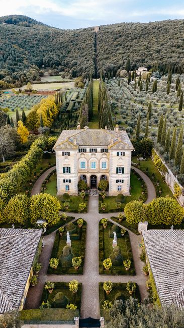 Explore the beauty of a classic Tuscan villa surrounded by lush gardens and cypress trees.