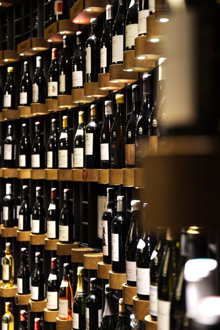 Luxurious wine cellar with assorted wine bottles in a Bordeaux restaurant, showcasing elegant shelving design.