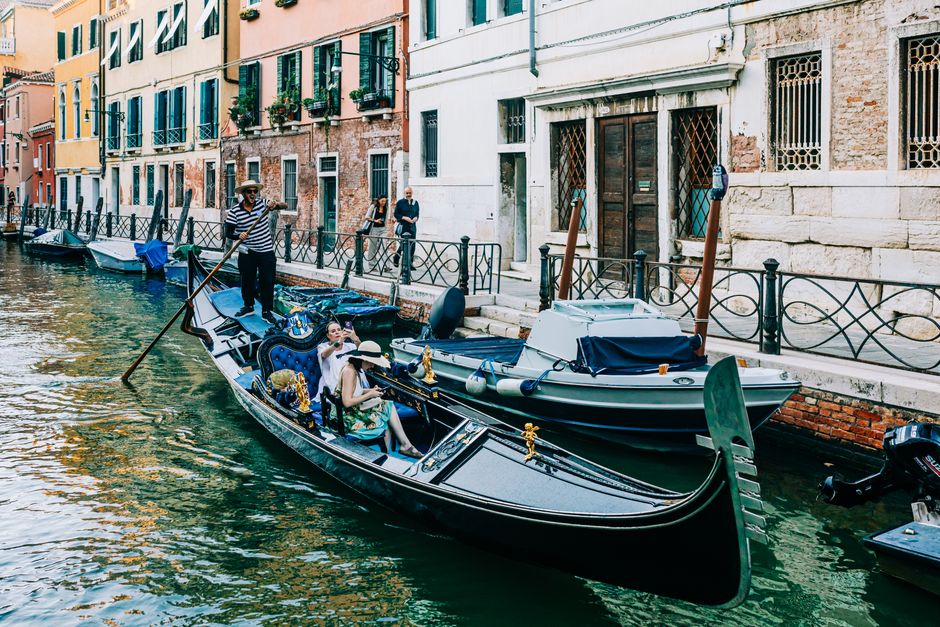 A serene gondola ride with tourists in beautiful Venice, Italy.