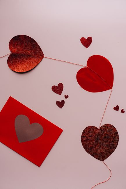 Red hearts and envelope arranged on a flat lay, perfect for Valentine's decor.
