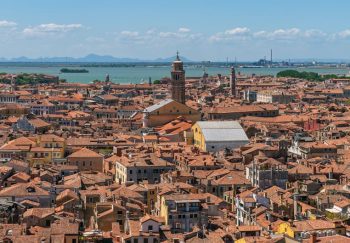 Stunning aerial view of Venice showcasing historic architecture and canals under a bright blue sky.