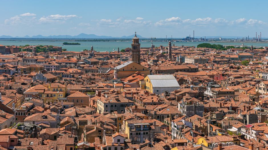 Stunning aerial view of Venice showcasing historic architecture and canals under a bright blue sky.